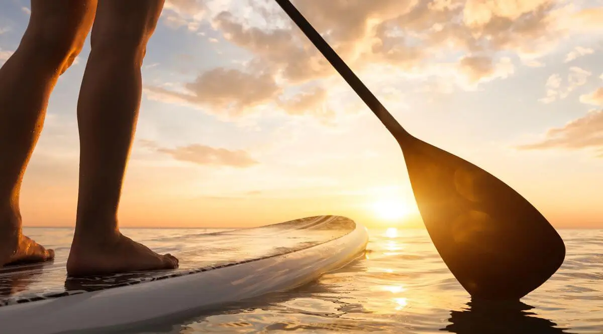 Woman Paddle Boarding at Sunset